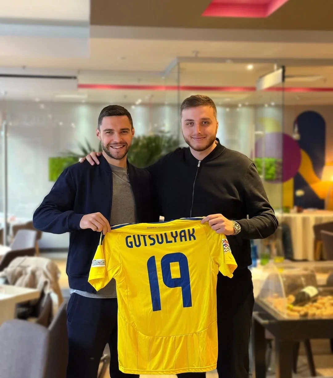 Олексій Гуцуляк тримає жовту футболку з прізвищем GUTSULYAK 19