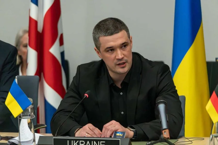 Михаил Федоров выступает за столом с табличкой UKRAINE среди флагов