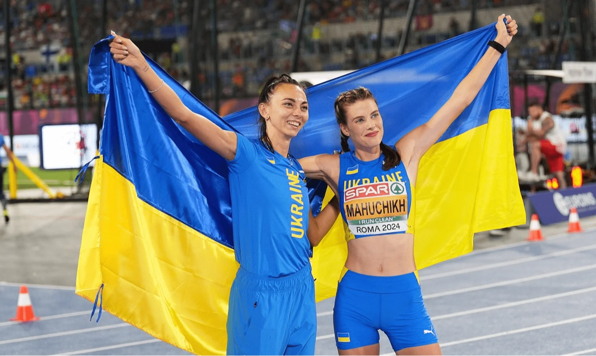 Ярослава Магучіх та українська легкоатлетка з прапором України на змаганнях