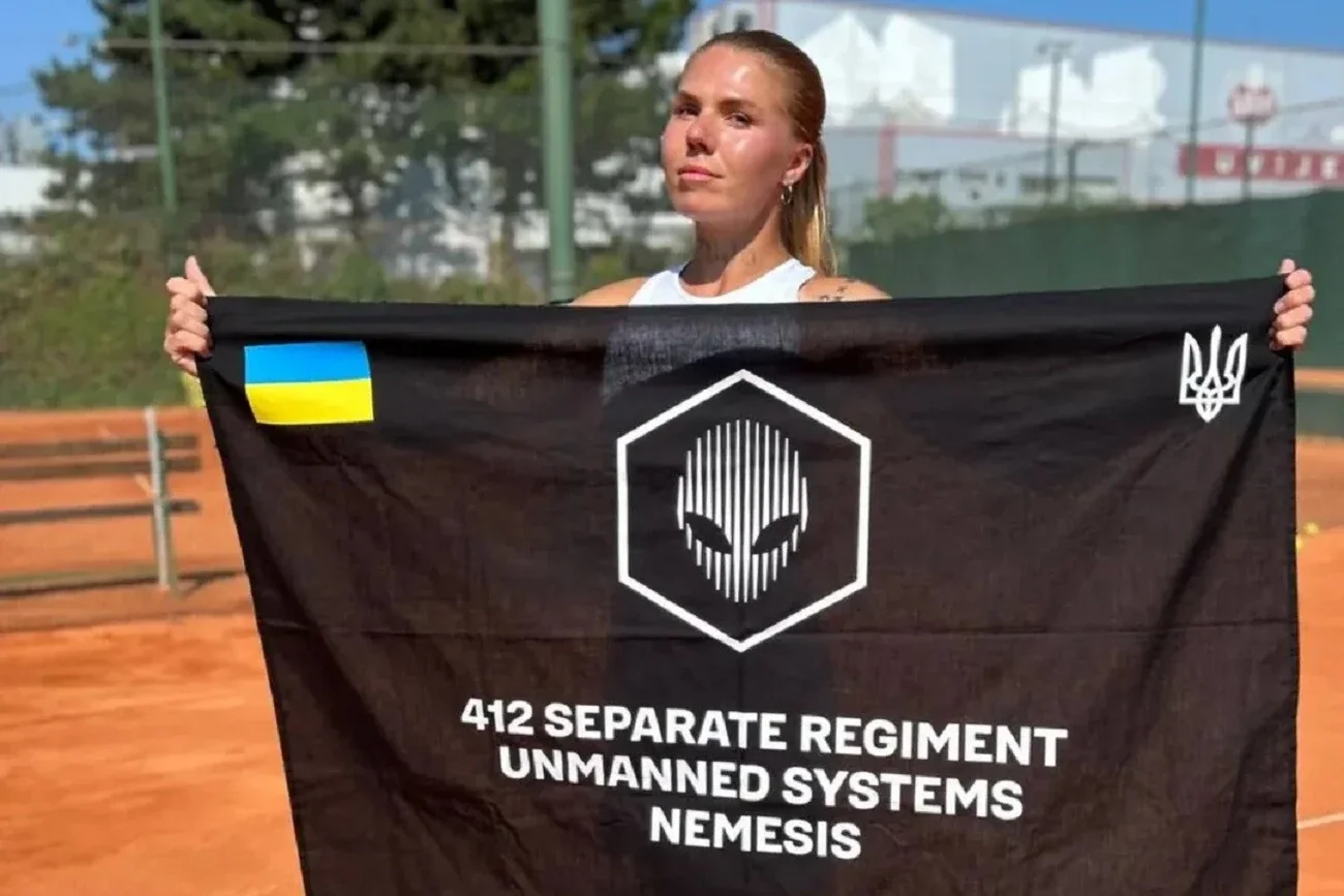 Олександра Олійникова тримає прапор 412 полку безпілотних систем Nemesis