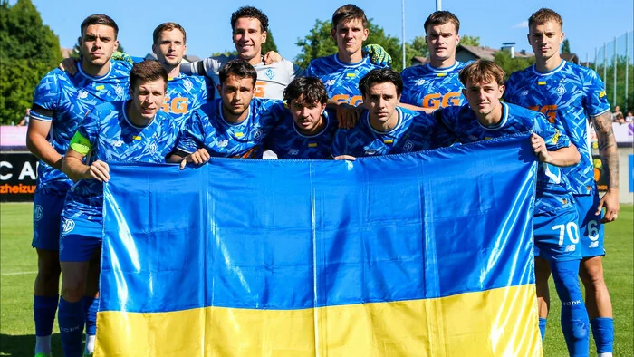 Гравці Першої ліги тримають прапор України на футбольному полі