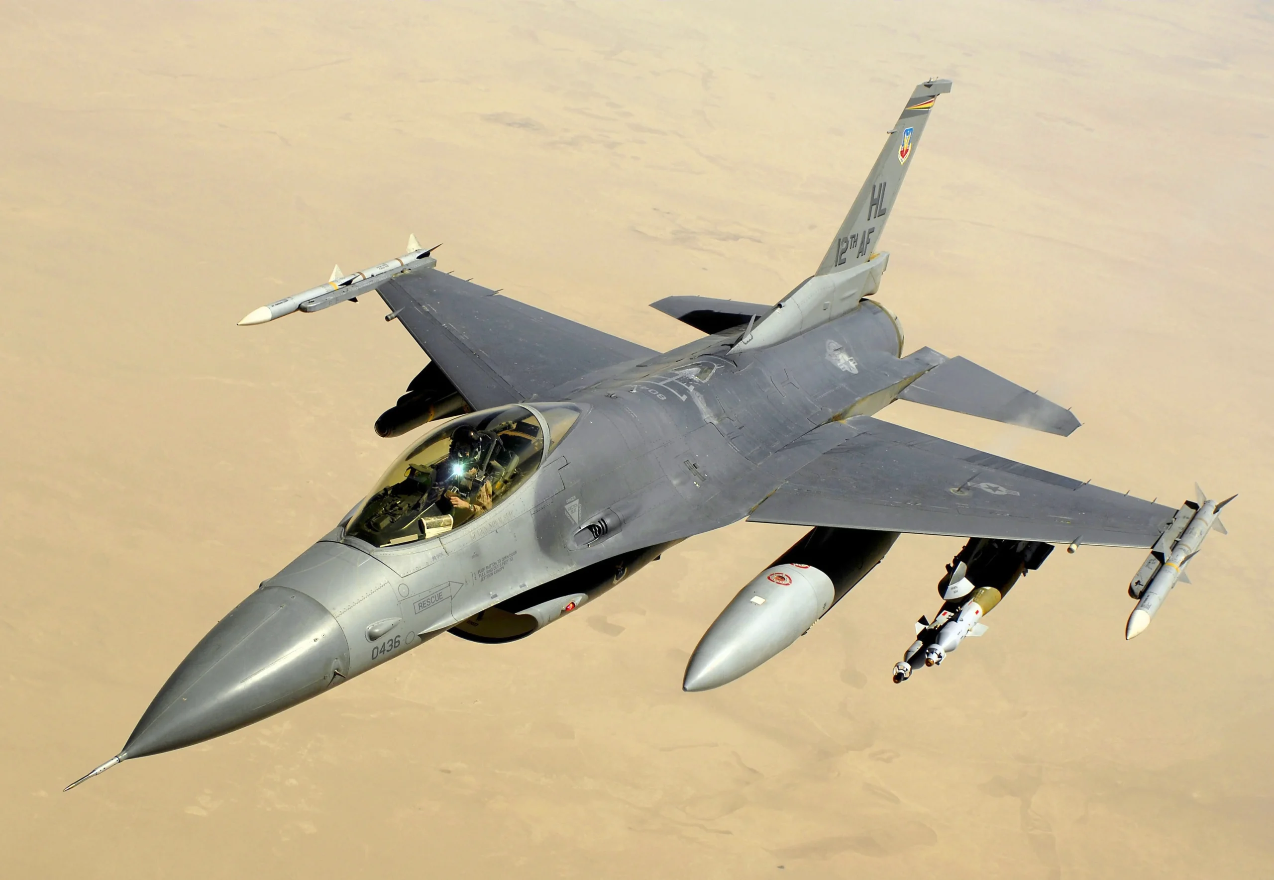 Американський винищувач F-16 летить над пустелею з ракетами під крилами
