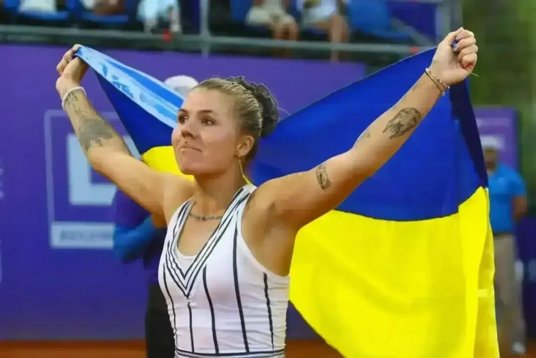 Українська тенісистка святкує з прапором України на турнірі WT
