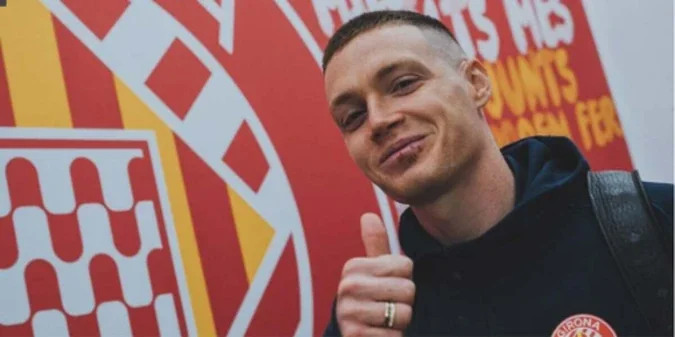 Віктор Циганков на тлі логотипу Жирони показує великий палець вгору