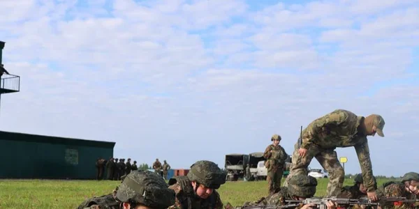 Білоруські солдати з автоматами тренуються на відкритому полігоні