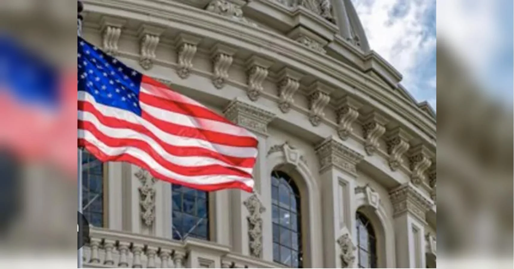 Прапор США майорить перед оздобленною купольною урядовою будівлею