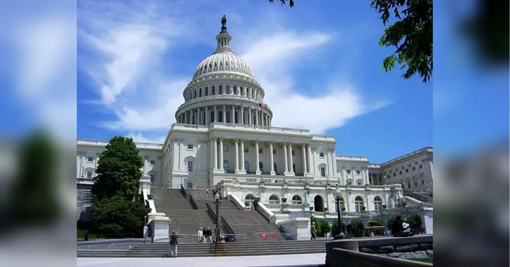 Білий Капітолій США з куполом, широкими сходами, деревами та людьми під блакитним небом